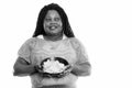 Studio shot of happy fat black African woman smiling and thinking while holding bowl of potato chips Royalty Free Stock Photo