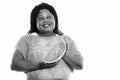 Studio shot of happy fat black African woman smiling and thinking while holding slice of watermelon Royalty Free Stock Photo