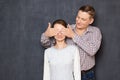 Studio shot of happy man covering eyes of cheerful woman Royalty Free Stock Photo