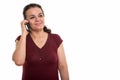 Studio shot of happy mature Persian woman smiling and thinking w Royalty Free Stock Photo