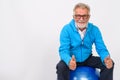 Studio shot of happy senior bearded man smiling and giving thumb Royalty Free Stock Photo