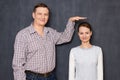 Studio shot of happy tall man and joyful short woman Royalty Free Stock Photo