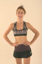 Studio shot of happy teenage girl smiling while standing and posing ready for sports and exercise against white Royalty Free Stock Photo