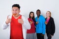 Studio shot of happy young Asian man eating slice of pizza while Royalty Free Stock Photo