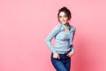 Studio shot of happy young fair-haired woman dressed casually jeans and blue blouse. pink background. copy space Royalty Free Stock Photo