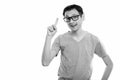 Studio shot of happy young man smiling with eyeglasses while pointing finger up Royalty Free Stock Photo