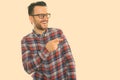 Studio shot of happy young man smiling and laughing while pointing at side Royalty Free Stock Photo