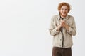 Studio shot of insane or crazy weird redhead guy with messy hair and beard staring with strange sick look rubbing hands Royalty Free Stock Photo