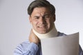 Studio Shot Of Man Wearing Neck Brace Reading Letter Royalty Free Stock Photo