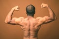 Muscular Indian man with mustache shirtless against brown background