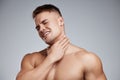 I went too far this time. Studio shot of a muscular young man experiencing neck pain against a grey background. Royalty Free Stock Photo