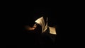 Studio shot of old retro hardcover book on dark background in warm light. Man holding showing old book in hands. Royalty Free Stock Photo