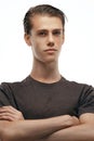 Studio shot of pensive young European male posing at blank wall, keeping arms crossed and looking above camera Royalty Free Stock Photo