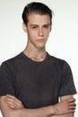 Studio shot of pensive young European male posing at blank wall, keeping arms crossed and looking at camera, nice and Royalty Free Stock Photo