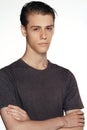 Studio shot of pensive young European male posing at blank wall, keeping arms crossed and looking at camera, nice and Royalty Free Stock Photo