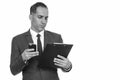 Mature handsome Persian businessman reading clipboard while holding mobile phone Royalty Free Stock Photo