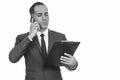 Mature handsome Persian businessman reading clipboard while talking on mobile phone Royalty Free Stock Photo