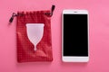 Studio shot of phone with blank screen for advertismant or promotional text and menstrual cup on checkered red case over