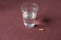 Pill And Glass Of Water On Red Royalty Free Stock Photo