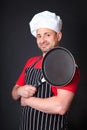 Studio shot of positive chef with a frying pan.