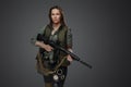Female mercenary with rifle isolated on grey background