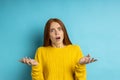 Studio shot of redhead caucasian young woman isolated blue background