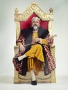 I took the throne peacefully. Studio shot of a richly garbed king sitting on a throne. Royalty Free Stock Photo