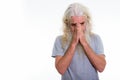 Studio shot of senior bearded man crying while covering face wit Royalty Free Stock Photo