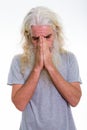 Studio shot of senior bearded man crying while looking down and Royalty Free Stock Photo