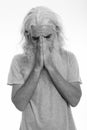 Studio shot of senior bearded man crying while looking down and covering face Royalty Free Stock Photo