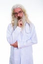 Studio shot of senior bearded man doctor thinking while looking Royalty Free Stock Photo