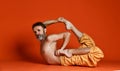 Studio shot of senior bearded man doing yoga poses and stretching his legs shirtless Royalty Free Stock Photo