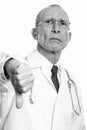 Studio shot of senior man doctor giving thumb down Royalty Free Stock Photo