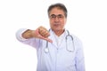 Studio shot of senior Persian man doctor giving thumb down Royalty Free Stock Photo