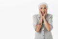 Studio shot of senior woman reacting on surprise. Portrait of touched and delighted cute old lady with white hair Royalty Free Stock Photo