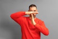 Studio shot of serious man in red jumper making time out gesture need to stop and asking for time to rest after hard Royalty Free Stock Photo