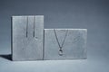 Studio shot of set of sterling silver jewelry dangle earrings and chain with pendant on concrete elements isolated over Royalty Free Stock Photo