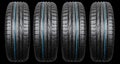 Studio shot of a set of summer car tire isolated on black background. Tire stack. Car tyre protector close up. Black rubber tire. Royalty Free Stock Photo