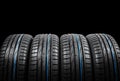 Studio shot of a set of summer car tires on black background. Tire stack background. Car tyre protector close up. Black rubber tir Royalty Free Stock Photo