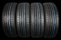 Studio shot of a set of summer car tires on black background. Tire stack background. Car tyre protector close up. Black rubber tir Royalty Free Stock Photo