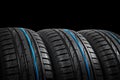 Studio shot of a set of summer car tires on black background. Tire stack background. Car tyre protector close up. Black rubber tir Royalty Free Stock Photo