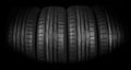 Studio shot of a set of summer car tires on black background. Tire stack background. Car tyre protector close up. Black rubber tir Royalty Free Stock Photo