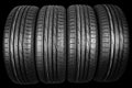 Studio shot of a set of summer car tires isolated on black background. Tire stack background. Car tyre protector close up. Black r Royalty Free Stock Photo