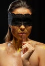 Sexy woman with gold makeup and lace mask, eating chocolate Royalty Free Stock Photo