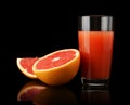 Studio shot sliced three grapefruits with juice isolated black