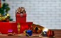 Studio shot of small and big red paper wrapped present gift boxes with gold and silver ribbon bow tie placed on wood table with Royalty Free Stock Photo