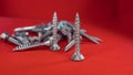 Small hex head screws on a red background Royalty Free Stock Photo
