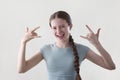 Studio Shot Of Smiling Teenage Girl Making Rebellious Rock And Roll Hand Gesture Looking Into Camera Royalty Free Stock Photo