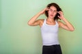 Studio shot of stressed teenage girl having headache against gre Royalty Free Stock Photo