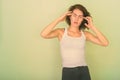 Studio shot of stressed teenage girl having headache against green painted wall Royalty Free Stock Photo